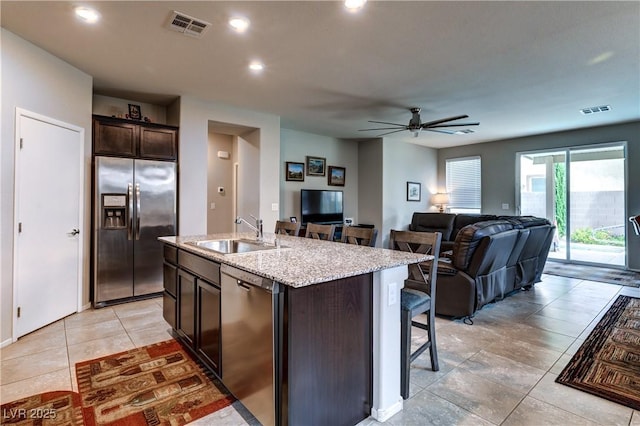5854 Olivine Falls Ave, Las Vegas, NV 89130 - kitchen featuring appliances with stainless steel finishes, a sink, dark brown cabinets, a breakfast bar, and ceiling fan