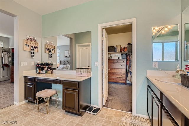 7761 Sagamore Bay Ct, Las Vegas, NV 89179 - bathroom featuring vanity, connected bathroom, a spacious closet, and baseboards