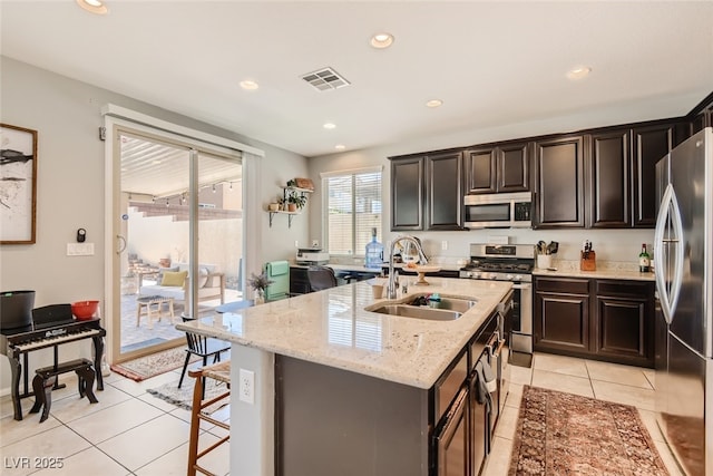 7761 Sagamore Bay Ct, Las Vegas, NV 89179 - kitchen featuring stainless steel appliances, a sink, light tile patterned floors, recessed lighting, and light stone countertops