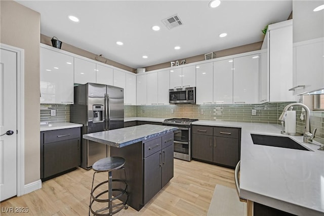 1780 Crystal Stream Ave, Henderson, NV 89012 - kitchen with appliances with stainless steel finishes, white cabinetry, a center island, a breakfast bar, and recessed lighting
