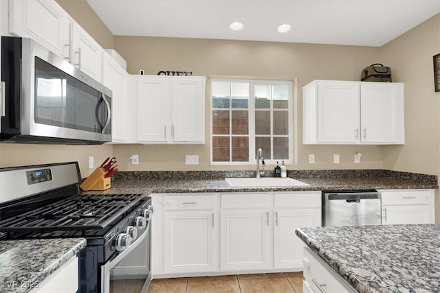 9869 Lime Tree St, Las Vegas, NV 89178 - kitchen featuring appliances with stainless steel finishes, a sink, dark stone countertops, white cabinets, and recessed lighting