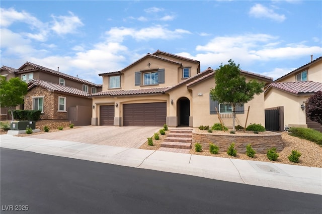 2575 Hazelburn Ave, Henderson, NV 89044 - mediterranean / spanish home featuring an attached garage, stucco siding, decorative driveway, and a tiled roof