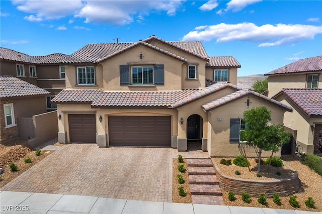 2575 Hazelburn Ave, Henderson, NV 89044 - mediterranean / spanish house featuring stucco siding, a garage, a tile roof, and decorative driveway