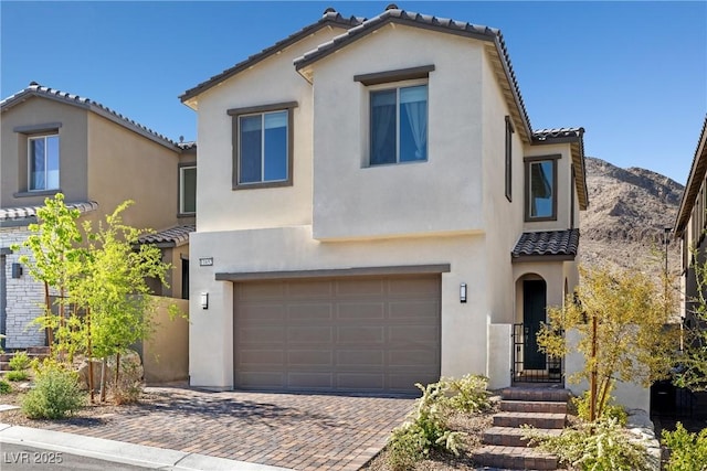 11652 Desert Hollow Ave, Las Vegas, NV 89138 - mediterranean / spanish house with a tile roof, stucco siding, a garage, and decorative driveway