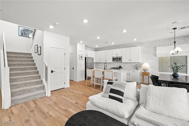 11652 Desert Hollow Ave, Las Vegas, NV 89138 - living room featuring stairs, light wood-style floors, and recessed lighting