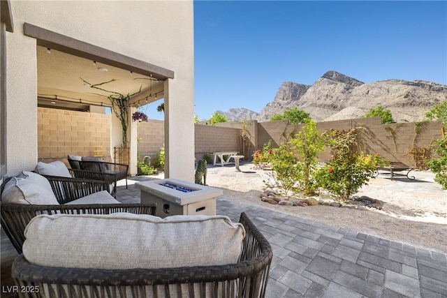 11652 Desert Hollow Ave, Las Vegas, NV 89138 - fenced backyard featuring a patio area, an outdoor living space with a fire pit, and a mountain view