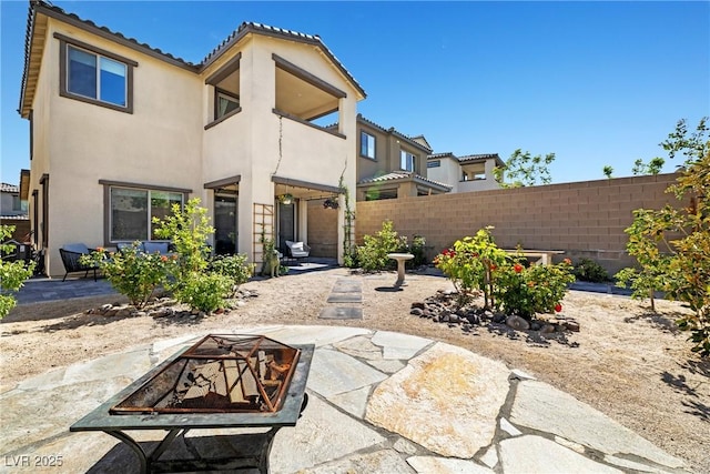 11652 Desert Hollow Ave, Las Vegas, NV 89138 - rear view of house with an outdoor fire pit, stucco siding, a balcony, and a patio