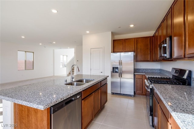 89 Via Franello, Henderson, NV 89011 - kitchen featuring stainless steel appliances, a sink, light stone countertops, brown cabinetry, and recessed lighting