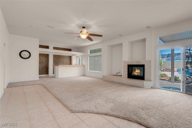 1312 Fragrant Spruce Ave, Las Vegas, NV 89123 - unfurnished living room with carpet floors, a tiled fireplace, tile patterned flooring, a ceiling fan, and baseboards