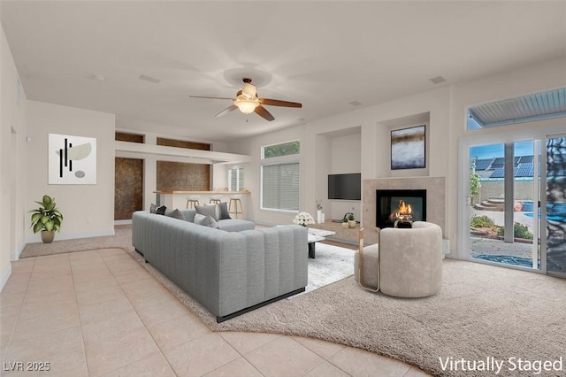1312 Fragrant Spruce Ave, Las Vegas, NV 89123 - living area featuring ceiling fan, light tile patterned floors, a tile fireplace, baseboards, and light colored carpet