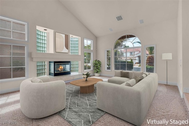 1312 Fragrant Spruce Ave, Las Vegas, NV 89123 - living area featuring high vaulted ceiling, a glass covered fireplace, baseboards, and plenty of natural light