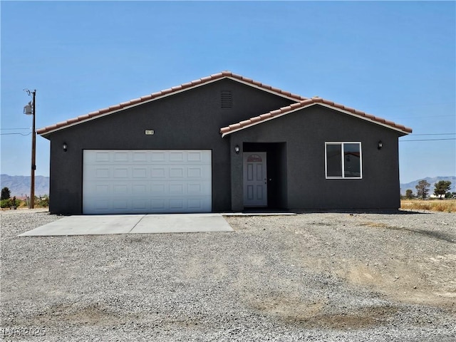 1870 Upland Ave, Pahrump, NV 89048 - ranch-style home with a tile roof, a mountain view, stucco siding, a garage, and driveway