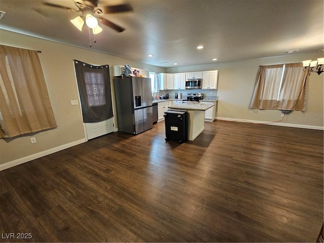 1870 Upland Ave, Pahrump, NV 89048 - kitchen with stainless steel appliances, a center island, light countertops, white cabinets, and dark wood-style floors