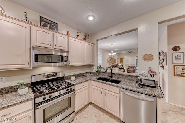 2522 Darda St, Henderson, NV 89044 - kitchen featuring appliances with stainless steel finishes, a sink, light tile patterned flooring, light stone countertops, and recessed lighting
