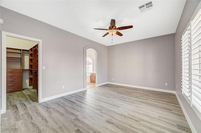 5931 Allanche Ave, Las Vegas, NV 89141 - unfurnished bedroom featuring a spacious closet, arched walkways, light wood finished floors, a closet, and ensuite bath