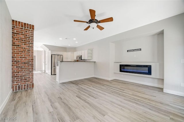 5931 Allanche Ave, Las Vegas, NV 89141 - unfurnished living room featuring light wood-style flooring, a ceiling fan, a glass covered fireplace, and recessed lighting