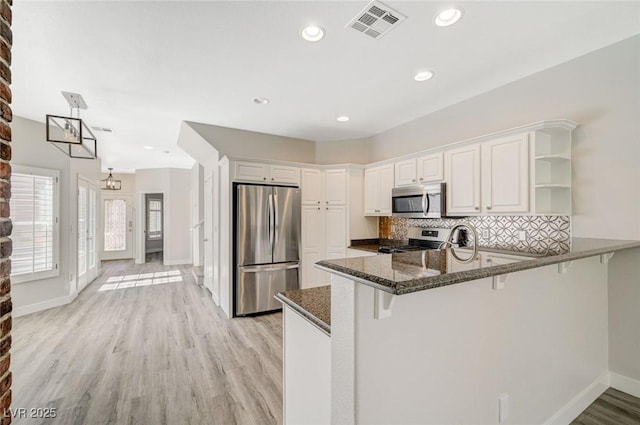 5931 Allanche Ave, Las Vegas, NV 89141 - kitchen featuring appliances with stainless steel finishes, open shelves, a peninsula, dark stone counters, and white cabinets