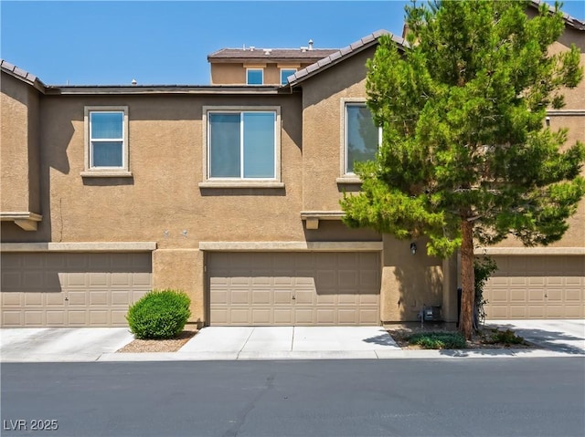 4563 Townwall St, Las Vegas, NV 89115 - view of front facade with stucco siding, an attached garage, and concrete driveway