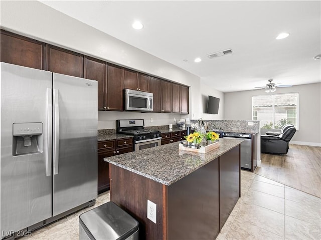 4563 Townwall St, Las Vegas, NV 89115 - kitchen featuring stainless steel appliances, a kitchen island, a peninsula, dark stone counters, and recessed lighting