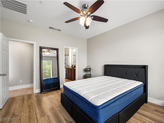 4563 Townwall St, Las Vegas, NV 89115 - bedroom with wood finished floors, baseboards, a ceiling fan, and connected bathroom
