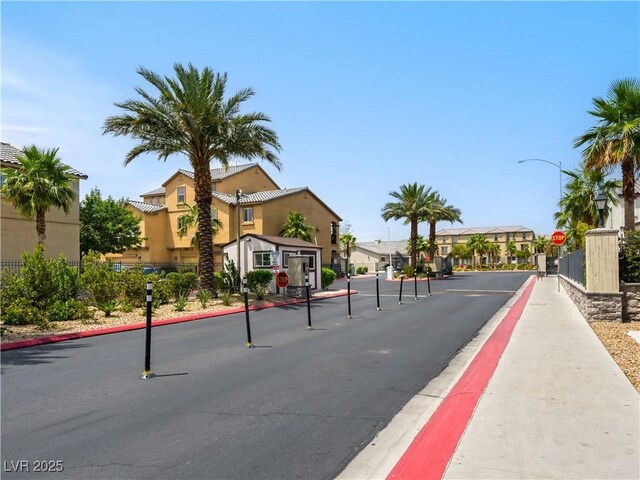 4563 Townwall St, Las Vegas, NV 89115 - view of asphalt street featuring traffic signs, curbs, sidewalks, a residential view, and street lights