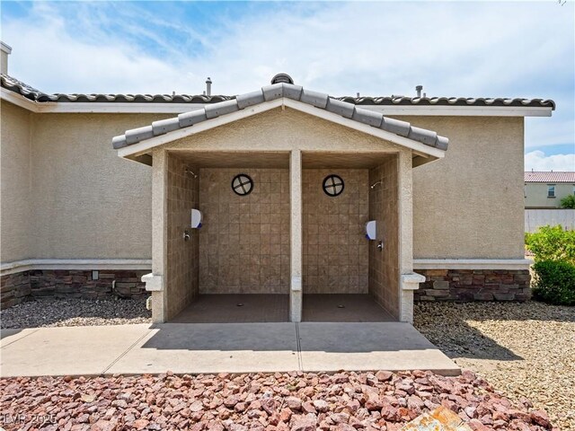 4563 Townwall St, Las Vegas, NV 89115 - property entrance featuring stucco siding, stone siding, and a tiled roof