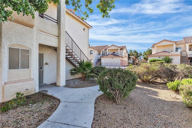 1300 S Arlington St Unit 120, Las Vegas, NV 89104 - view of property exterior featuring stucco siding, stairs, and a residential view