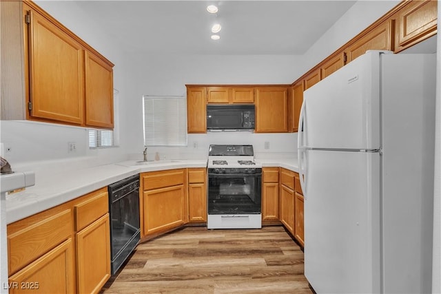 1300 S Arlington St Unit 120, Las Vegas, NV 89104 - kitchen with black appliances, light wood finished floors, a sink, and light countertops