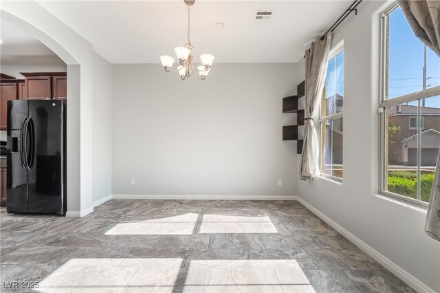 10917 Mount Pendleton St, Las Vegas, NV 89179 - unfurnished dining area with plenty of natural light, a chandelier, arched walkways, and baseboards