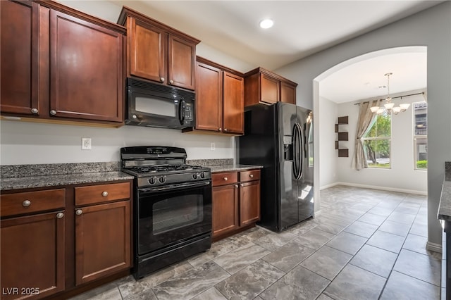 10917 Mount Pendleton St, Las Vegas, NV 89179 - kitchen with black appliances, a chandelier, arched walkways, dark stone countertops, and baseboards