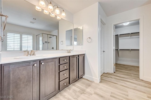 7372 S Palo Real Ct, Las Vegas, NV 89179 - full bath featuring a shower stall, wood finished floors, double vanity, and a walk in closet
