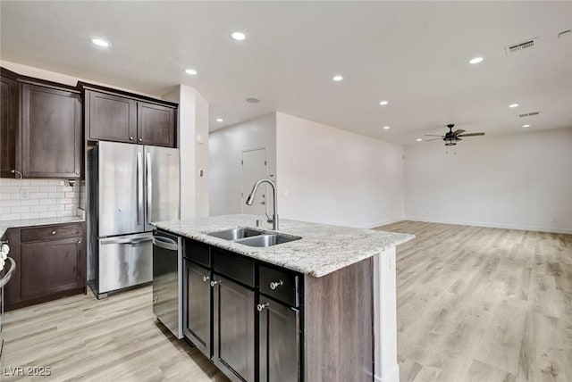 7372 S Palo Real Ct, Las Vegas, NV 89179 - kitchen with appliances with stainless steel finishes, a ceiling fan, light wood-style flooring, recessed lighting, and light stone countertops