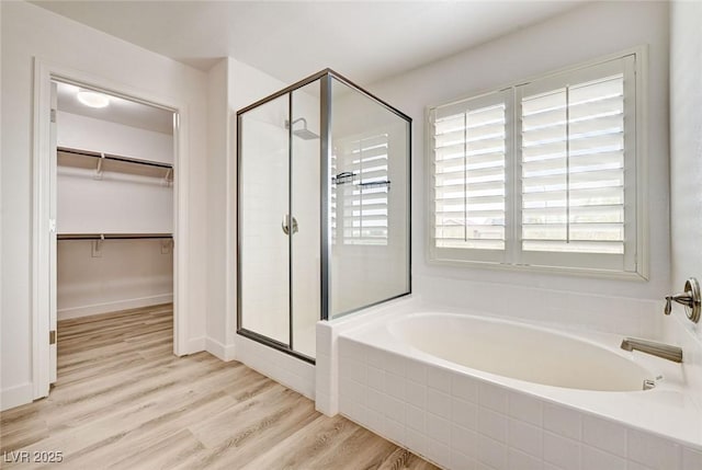 7372 S Palo Real Ct, Las Vegas, NV 89179 - bathroom with a shower stall, a bath, wood finished floors, and a walk in closet