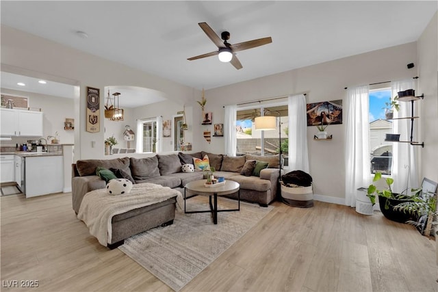 6108 Shallow Springs St, Las Vegas, NV 89130 - living room featuring light wood-style floors, a ceiling fan, arched walkways, and baseboards