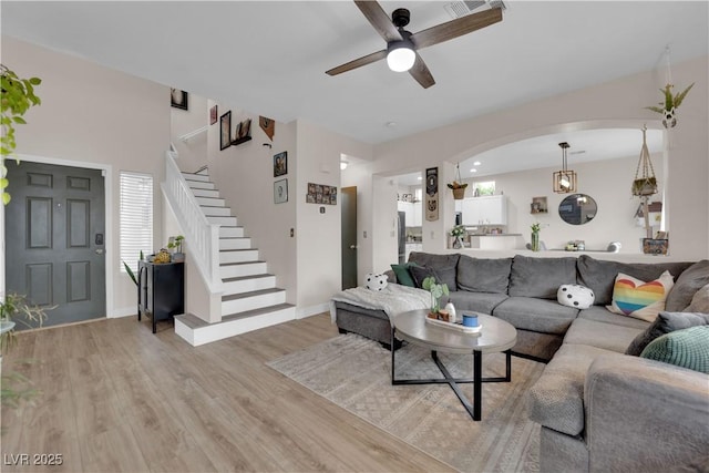 6108 Shallow Springs St, Las Vegas, NV 89130 - living area with stairs, a ceiling fan, light wood-type flooring, arched walkways, and baseboards