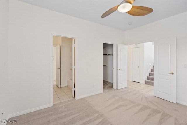 10680 Sapphire Vista Ave, Las Vegas, NV 89144 - unfurnished bedroom with carpet flooring, baseboards, tile patterned flooring, connected bathroom, and a walk in closet