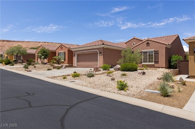 1407 Wheelwright Ct, Mesquite, NV 89034 - mediterranean / spanish-style house with stucco siding, an attached garage, concrete driveway, and a tiled roof