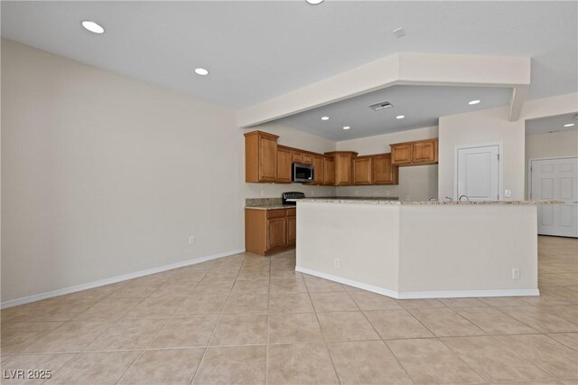 1407 Wheelwright Ct, Mesquite, NV 89034 - kitchen with stainless steel microwave, recessed lighting, brown cabinets, and light stone counters