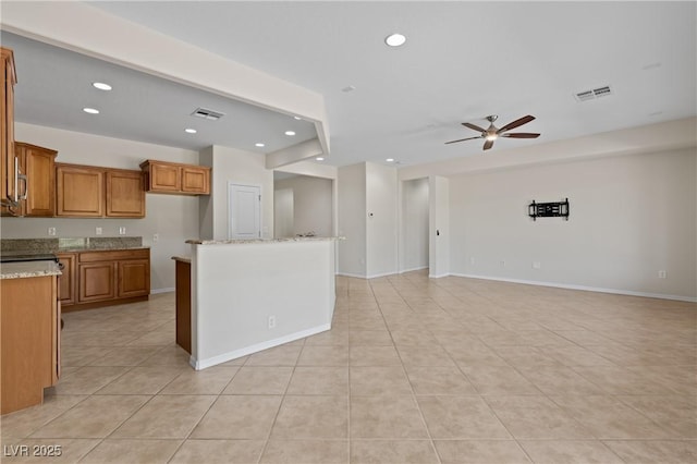 1407 Wheelwright Ct, Mesquite, NV 89034 - kitchen with brown cabinets, a ceiling fan, open floor plan, light tile patterned floors, and recessed lighting