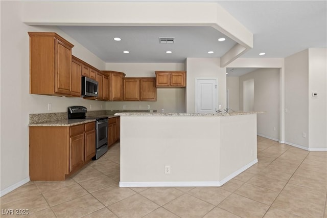 1407 Wheelwright Ct, Mesquite, NV 89034 - kitchen featuring appliances with stainless steel finishes, brown cabinets, recessed lighting, and light tile patterned flooring