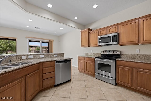 1407 Wheelwright Ct, Mesquite, NV 89034 - kitchen with appliances with stainless steel finishes, a sink, brown cabinets, light tile patterned floors, and recessed lighting