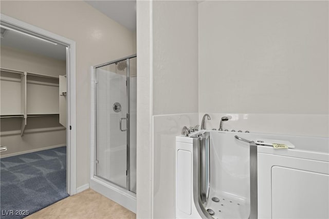 1407 Wheelwright Ct, Mesquite, NV 89034 - bathroom with a stall shower, a walk in closet, a bath, and tile patterned flooring