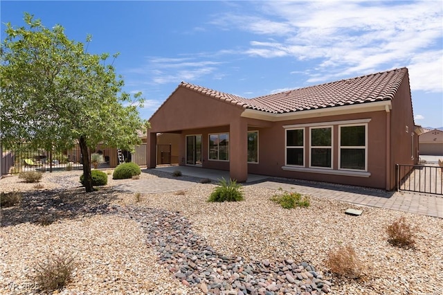 1407 Wheelwright Ct, Mesquite, NV 89034 - rear view of house with a patio area, stucco siding, and a tiled roof