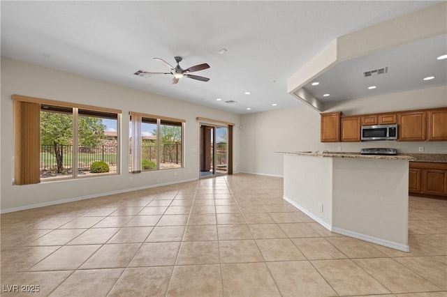 1407 Wheelwright Ct, Mesquite, NV 89034 - kitchen featuring stainless steel microwave, a ceiling fan, light tile patterned floors, electric stove, and light stone countertops