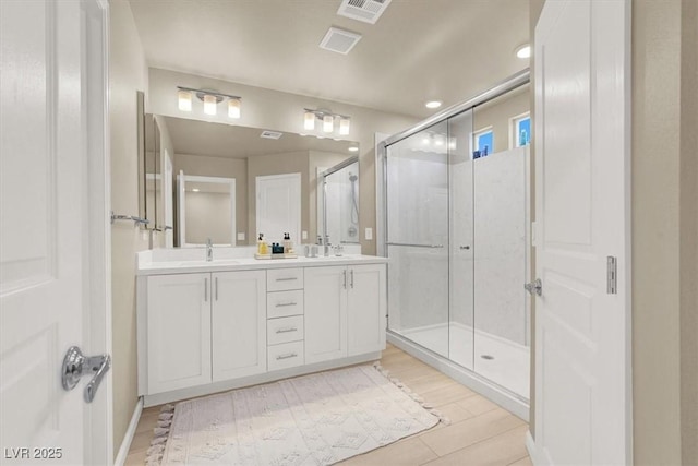 8060 Haywood Estate Ave, Las Vegas, NV 89113 - full bathroom with double vanity, a shower stall, wood finished floors, and recessed lighting