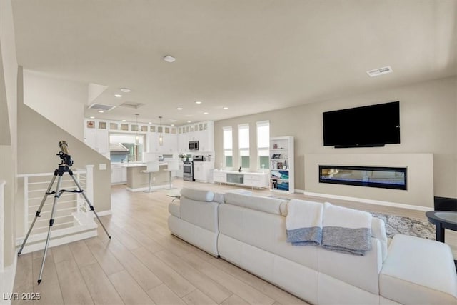 8060 Haywood Estate Ave, Las Vegas, NV 89113 - living room with light wood finished floors, recessed lighting, baseboards, and a glass covered fireplace