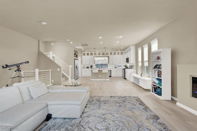 8060 Haywood Estate Ave, Las Vegas, NV 89113 - living room with light wood-style floors, stairs, recessed lighting, and baseboards