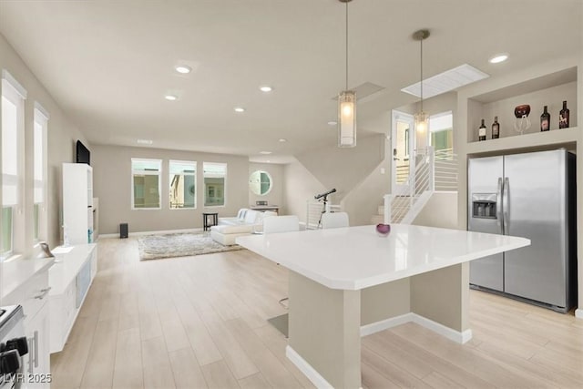 8060 Haywood Estate Ave, Las Vegas, NV 89113 - kitchen with stainless steel fridge with ice dispenser, light wood-style floors, a kitchen island, decorative light fixtures, and recessed lighting