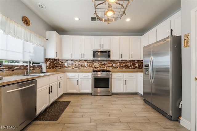 632 Monument Point St, Henderson, NV 89002 - kitchen with appliances with stainless steel finishes, a sink, light countertops, decorative backsplash, and recessed lighting