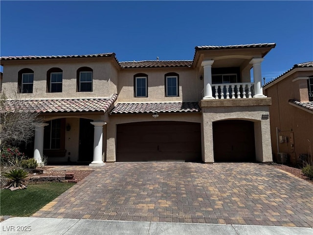 6454 Mount Palomar Ave, Las Vegas, NV 89139 - mediterranean / spanish-style house with a garage, a balcony, a tiled roof, decorative driveway, and stucco siding